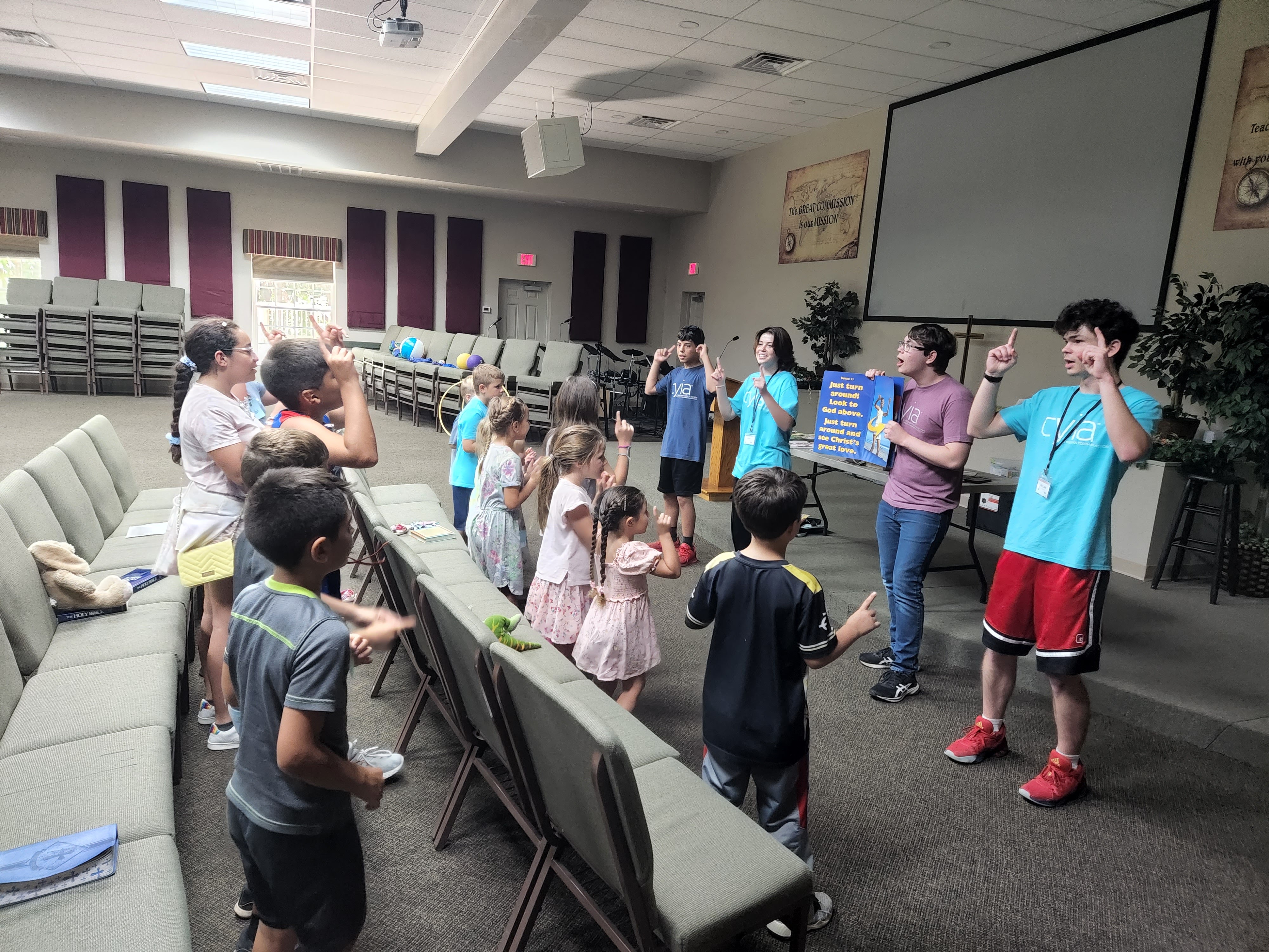 Children raising their hands during a ministry program, filled with joy and excitement